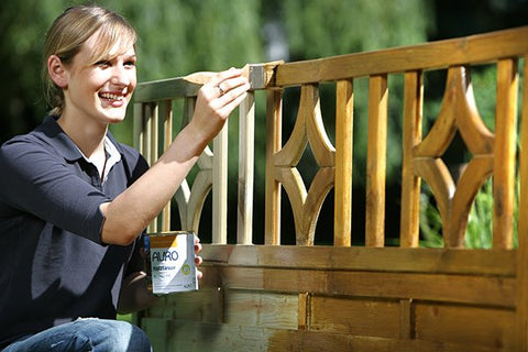 Painting a wooden garden trellis with natural wood stain
