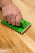 Osmo Hand Pad Holder with applicator fleece being used to oil a wooden floor by hand