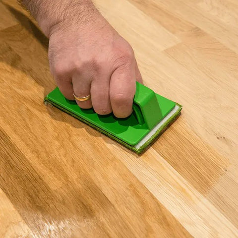 Osmo Hand Pad Holder with applicator fleece being used to oil a wooden floor by hand